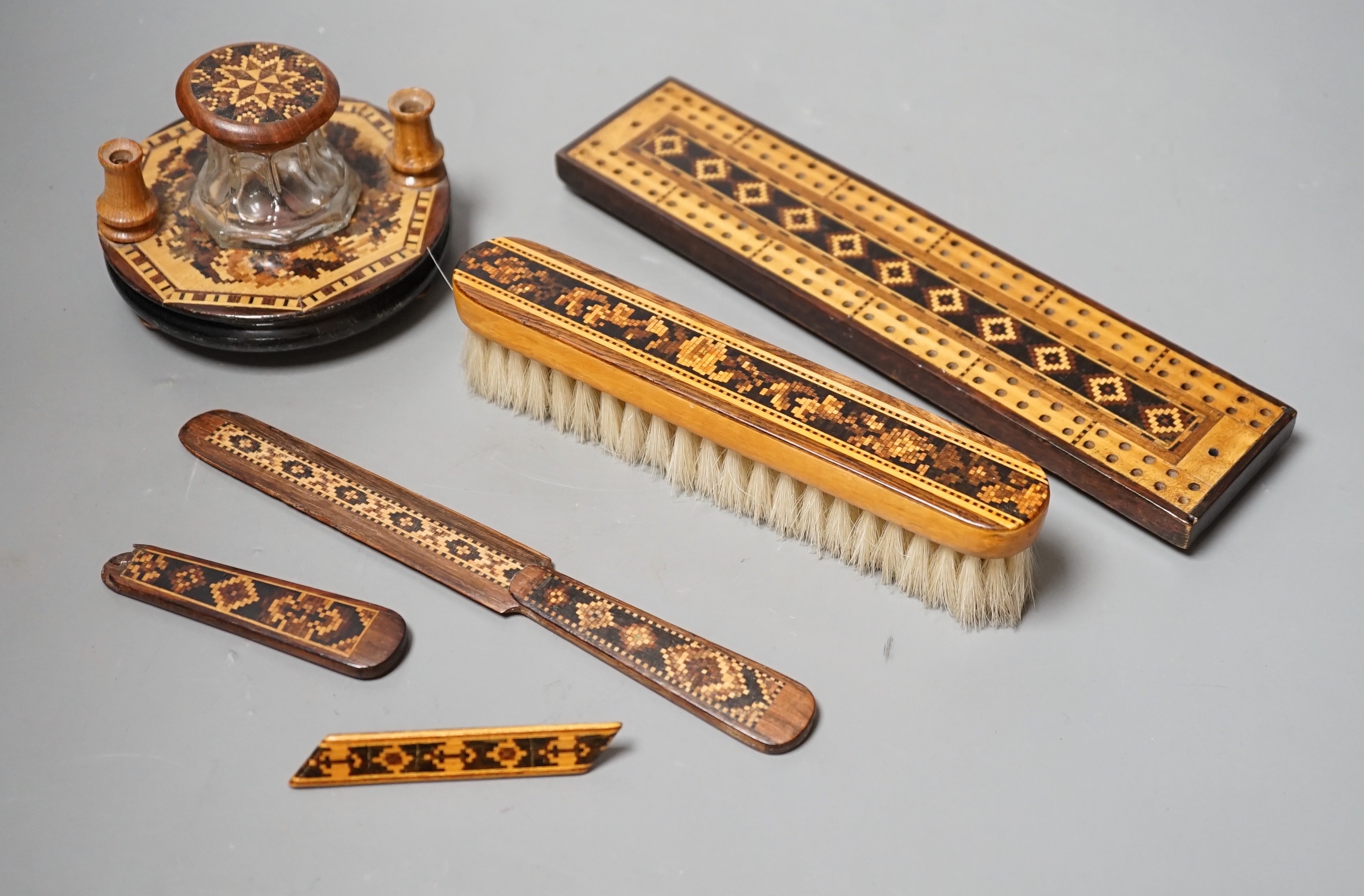 A group of Tunbridge ware to include an inkstand, two paper knives (one a handle only), cribbage board, a brush and a brooch